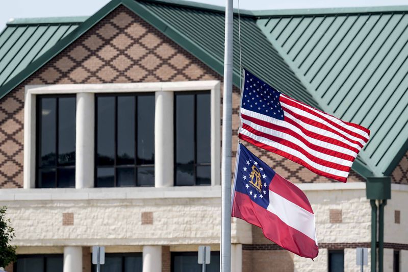 The American and state of Georgia flags fly half-staff after a shooting Wednesday at Apalachee High School, Thursday, Sept. 5, 2024, in Winder, Ga. (AP Photo/Mike Stewart)