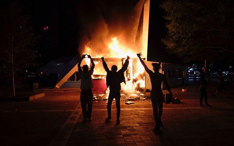 Protesters stand in front of a burning vendor cart outside of the visitor bureau office in Centennial Olympic Park on Friday, May 29, 2020, in Atlanta. (Photo: Ben Gray for The Atlanta Journal-Constitution)