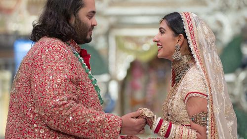 In this photo provided by Reliance Industries, Anant Ambani, left, the son of billionaire Mukesh Ambani, holds hands with Radhika Merchant during their wedding ceremony at Jio World Convention Centre in Mumbai, India, Friday, July 12, 2024. (Reliance Industries via AP)