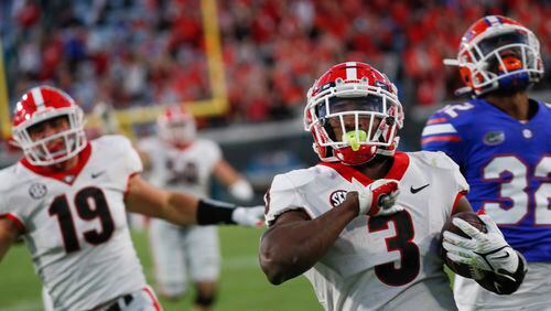 Georgia Bulldogs running back Zamir White (3) scores on this fourth-quarter touchdown run during the second half of the annual Georgia vs Florida game at TIAA Bank Field in Jacksonville. Georgia won 34-7.  Bob Andres / bandres@ajc.com