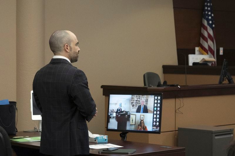 Arizona Attorney General Criminal Division Chief Nick Klingerman, left, speaks during the video arraignment Mark Meadows, top right on monitor, former Chief of Staff to President Donald Trump, Friday, June 7, 2024, in Maricopa County Superior Court in Phoenix. Meadows pleaded not guilty Friday to nine felony charges for his role in an effort to overturn Trump's Arizona election loss to Joe Biden. (Mark Henle/The Arizona Republic via AP)