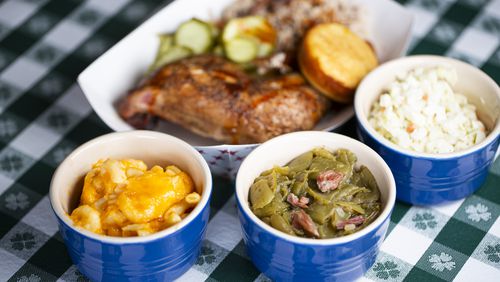 Green beans (center) featured with (clockwise from left) macaroni and cheese, barbecue chicken and pork, pickles, cornbread and coleslaw from McDaniels QN2 BBQ. (Ryan Fleisher for The Atlanta Journal-Constitution)