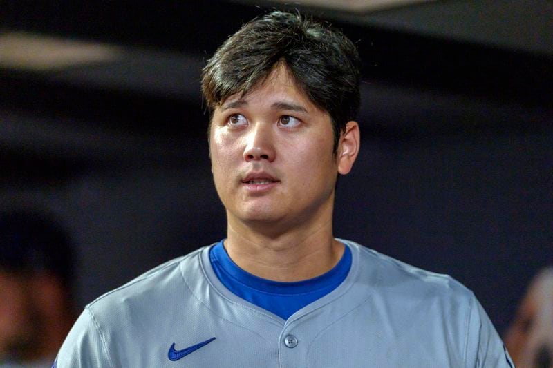 Los Angeles Dodgers two-way player Shohei Ohtani checks the scoreboard from the dugout in the third inning of a baseball game against the Atlanta Braves, Monday, Sept. 16, 2024, in Atlanta. (AP Photo/Jason Allen)