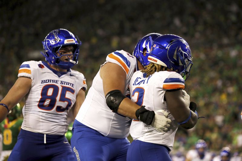 Boise State tight end Matt Lauter (85) and offensive tackle Hall Schmidt (65) congratulate running back Ashton Jeanty (2) on a touchdown during the first half of an NCAA college football game, Saturday, Sept. 7, 2024, at Autzen Stadium in Eugene, Ore. (AP Photo/Lydia Ely)