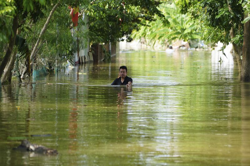 A man wades in chest deep flood in the aftermath of Typhoon Yagi in An Lac village, Hanoi, Vietnam Friday, Sept. 13, 2024. (AP Photo/Hau Dinh)