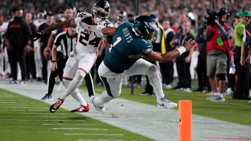 Philadelphia Eagles quarterback Jalen Hurts (1) is pushed out of bounds during the second half of an NFL football game by Atlanta Falcons cornerback A.J. Terrell (24) on Monday, Sept. 16, 2024, in Philadelphia. (AP Photo/Matt Rourke)