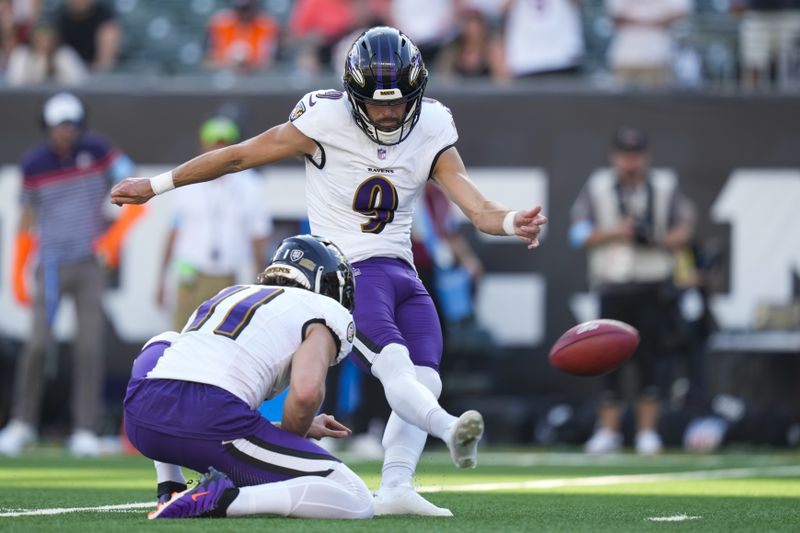 Baltimore Ravens kicker Justin Tucker (9), with Jordan Stout holding, boots the game winning field goal in overtime of an NFL football game, Sunday, Oct. 6, 2024, in Cincinnati. The Ravens won 41-38 in overtime. (AP Photo/Carolyn Kaster)