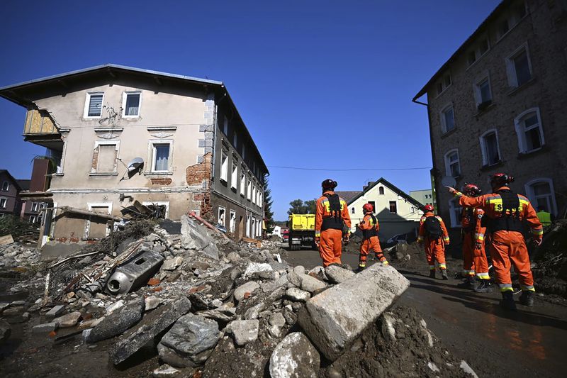 On this handout photo provided by the State Fire Service of Poland, firefighters inspecting safety of houses following heavy flooding in the town of Stronie Slaskie, southwestern Poland, Wednesday, Sept. 18, 2024. (Tomasz Fijołek/KG PSP via AP)