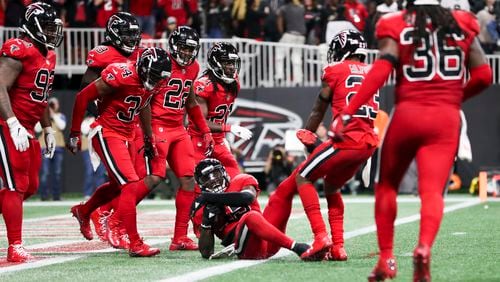 Atlanta Falcons cornerback Robert Alford (23) drags Atlanta Falcons middle linebacker Deion Jones (45) out of the New Orleans Saints end zone after he intercepted the ball Thursday, Dec. 7, 2017, at Mercedes-Benz Stadium in Atlanta.