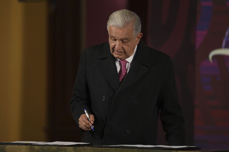 Mexican President Andres Manuel Lopez Obrador signs a law that puts the National Guard under the command of the military during his last morning press conference, "La Mañanera," at the National Palace in Mexico City, Monday, Sept. 30, 2024. (AP Photo/Fernando Llano)