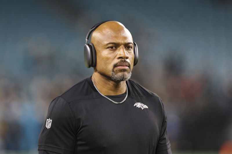 Baltimore Ravens assistant head coach/defensive line Anthony Weaver walks the field before an NFL football game against the Jacksonville Jaguars, Sunday, Dec. 17, 2023, in Jacksonville, Fla. The Ravens defeated the Jaguars 23-7. (AP Photo/Gary McCullough)