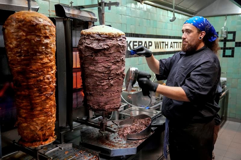 Doner chef Hvesley Silva cuts doner kebab in a doner kebab restaurant in Berlin, Germany, Monday, Sept. 16, 2024. (AP Photo/Ebrahim Noroozi)