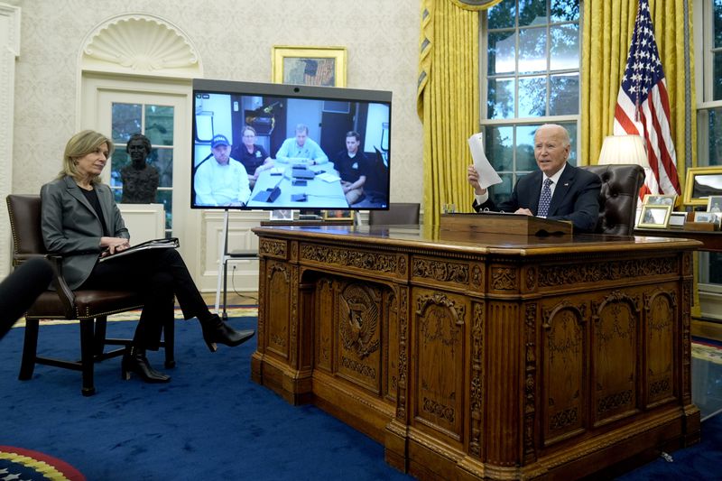 President Joe Biden, right, and White House Homeland Security Advisor Liz Sherwood-Randall, left, speak with North Carolina Gov. Roy Cooper, on screen at center right, and Administrator of the U.S. Federal Emergency Management Agency Deanne Criswell, onscreen at center left, about the Biden administration's efforts to aid in recovery from the aftermath of Hurricane Helene from the Oval Office of the White House in Washington, Monday, Sept. 30, 2024. (AP Photo/Mark Schiefelbein)