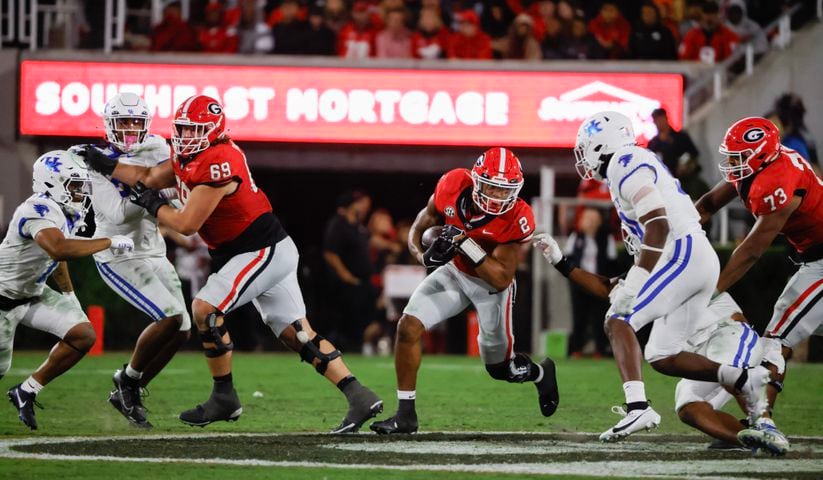  Georgia Bulldogs running back Kendall Milton (2) runs for a first down with blocking from offensive lineman Tate Ratledge (69) and offensive lineman Xavier Truss (73) during the second half.  (Bob Andres for the Atlanta Journal Constitution)