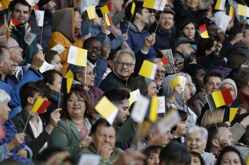 Faithful wave flags as Pope Francis arrives to lead the holy mass , at the King Baudouin stadium in Brussels, Belgium, Sunday, Sept. 29, 2024. (AP Photo/Omar Havana)