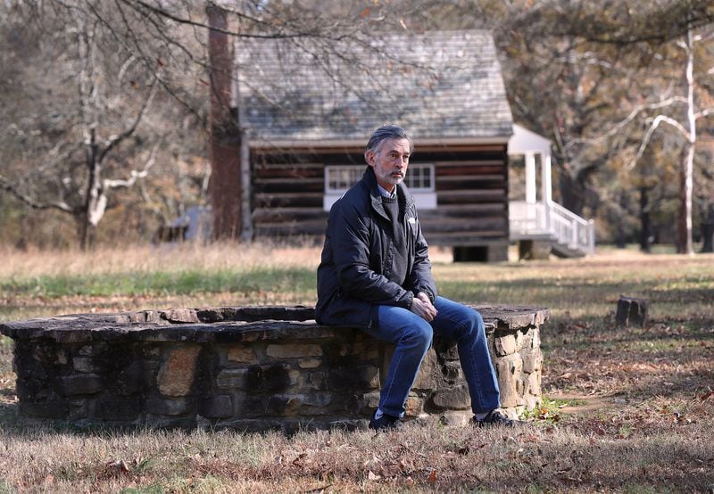 120820 Calhoun: Cherokee Indian decendant John Perry sits on the original well at the Boudinot house site where the Treaty of New Echota was signed at the New Echota Historic Site on Tuesday, Dec. 8, 2020, in Calhoun. New Echota is one of the most significant Cherokee Indian sites in the nation and marks the beginning of the tragic Trail of Tears.     “Curtis Compton / Curtis.Compton@ajc.com”