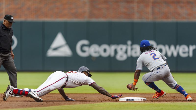 Atlanta Braves' Jorge Soler, left, slides into second base before New York Mets shortstop Luisangel Acuna, right, can tag him in the second inning of the second baseball game of a doubleheader, Monday, Sept. 30, 2024, in Atlanta. (AP Photo/Jason Allen)