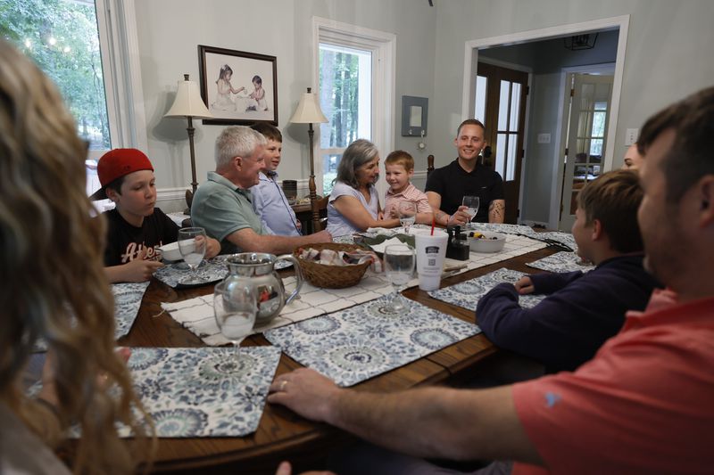 Steve and Dale Tingle hold their grandkids while Kevin Krüger smiles during a Sunday afternoon brunch in Watkinsville, Ga. Krüger, who lives in Germany, has formed a strong bond with the Tingle family after Dale Tingle donated stem cells to him, ultimately saving his life 13 years ago. (Miguel Martinez/AJC)