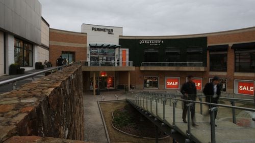 Shoppers walk up the entrance ramp at the main entrance to Perimeter Mall in a file photo.