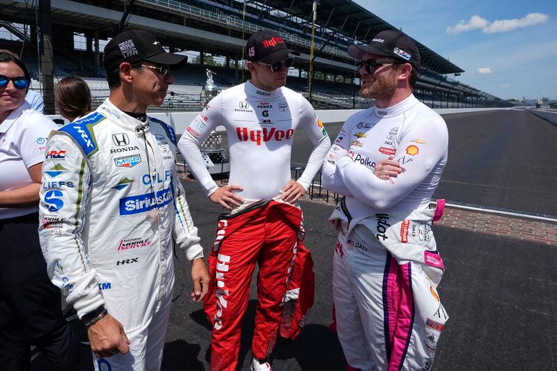 Helio Castroneves, from left, of Brazil, Christian Lundgaard, of Denmark, and Conor Daly talk before a practice session for the Indianapolis 500 auto race at Indianapolis Motor Speedway, Monday, May 20, 2024, in Indianapolis. (AP Photo/Darron Cummings)