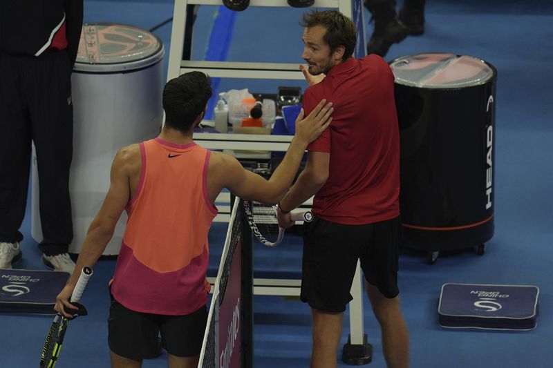 Carlos Alcaraz of Spain consoles Daniil Medvedev of Russia after their men's singles semi-final match for the China Open tennis tournament held at the National Tennis Center in Beijing, Tuesday, Oct. 1, 2024. (AP Photo/Ng Han Guan)