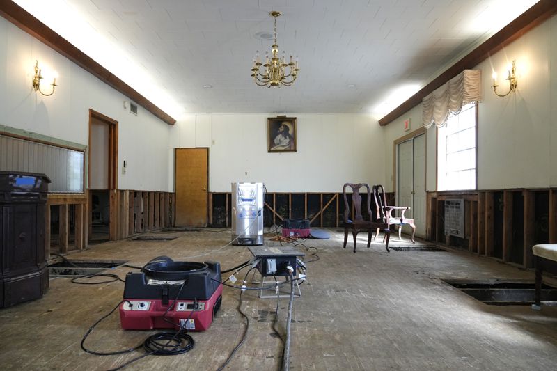 Air movers circulate the air in an effort to dry out the chapel inside Costner-Maloy Funeral Home Saturday, Oct. 5, 2024, which was flooded in the aftermath of Hurricane Helene, in Newport, Tenn. (AP Photo/Jeff Roberson)