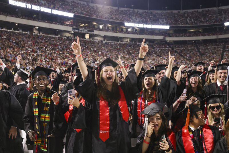 University of Georgia students of the C. Herman and Mary Virginia Terry College of Business react as their degrees are conferred during the Spring Undergraduate Commencement at Sanford Stadium, Friday, May 12, 2023, in Athens, Ga. (Jason Getz / Jason.Getz@ajc.com)