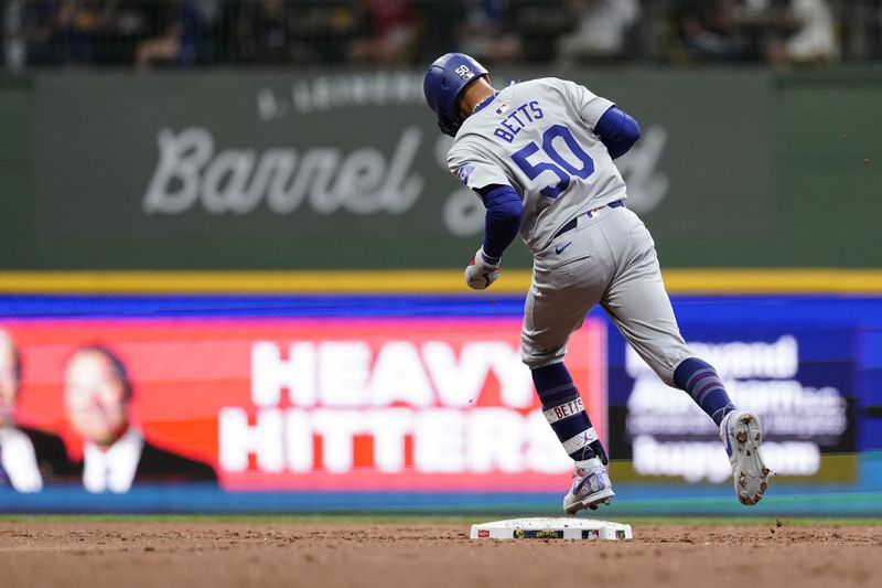 Los Angeles Dodgers' Mookie Betts rounds the bases after hitting a two-run home run during the third inning of a baseball game against the Milwaukee Brewers, Monday, Aug. 12, 2024, in Milwaukee. (AP Photo/Aaron Gash)