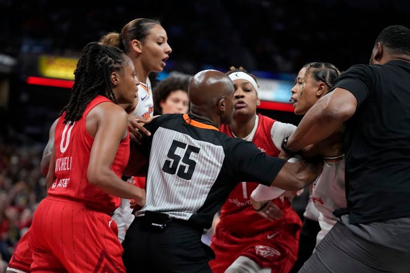 Indiana Fever's Kelsey Mitchell, left, and Phoenix Mercury's Natasha Cloud, second from right, have to be separated during the second half of a WNBA basketball game, Friday, Aug. 16, 2024, in Indianapolis. (AP Photo/Darron Cummings)