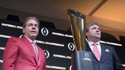 Alabama head coach Nick Saban, left, and Georgia head coach Kirby Smart pose for a photo with the College Football National Championship trophy following the head coaches press conference in the Grand Ballroom at the Sheraton hotel in Atlanta, Sunday, January 7, 2018.  (ALYSSA POINTER/ALYSSA.POINTER@AJC.COM)