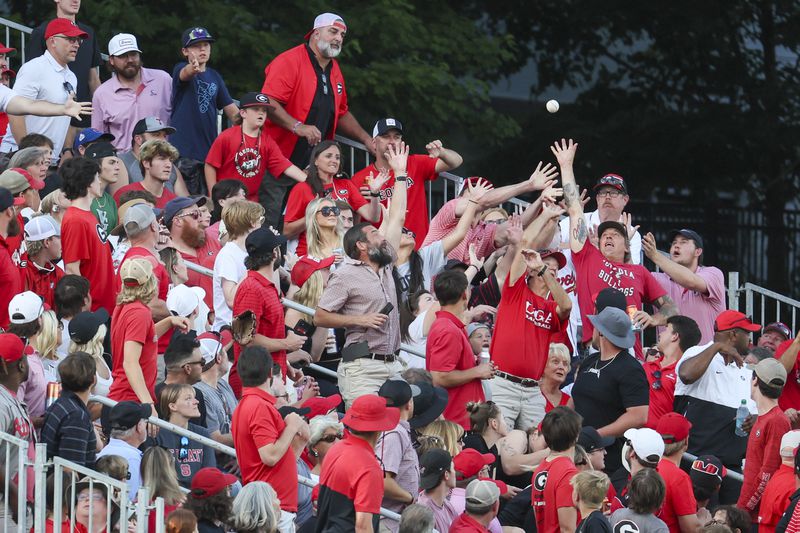 Georgia fans in the left field bleachers try to catch a foul ball hit by a N.C. State batter during the second inning in Game 3 of the NCAA Super Regional at Foley Field, Monday, June 10, 2024, in Athens, Ga. (Jason Getz / AJC)
