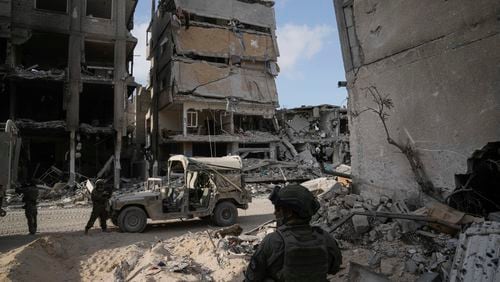 Israeli soldiers take up position next to buildings destroyed by the Israeli military in the Gaza Strip on Friday, Sept. 13, 2024. (AP Photo/Leo Correa)