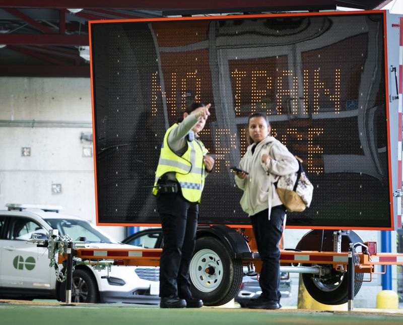 Commuters at the GO Bus Terminal Aug. 22, 2024 gets instructions as train service from Hamilton has been interrupted by the labor dispute with the two major Canadian railways on Thursday, Aug. 22, 2024 in Hamilton, Ontario. (Peter Power/The Canadian Press via AP)