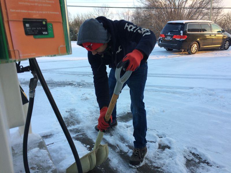 Harry Patel shovels snow at his BP station in Blue Ridge Saturday.