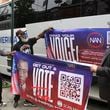 Organizers with the National Action Network put up banners for a Get Out the Vote event as the prepare to depart on a bus tour toward Philadelphia in the Harlem neighborhood of New York on Friday, Sep. 27, 2024. (AP Photo/Noreen Nasir)