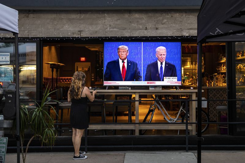 In this October 2020 file photo, a woman is seen watching a debate between then-President Donald Trump and former Vice President Joe Biden, who won the November election.