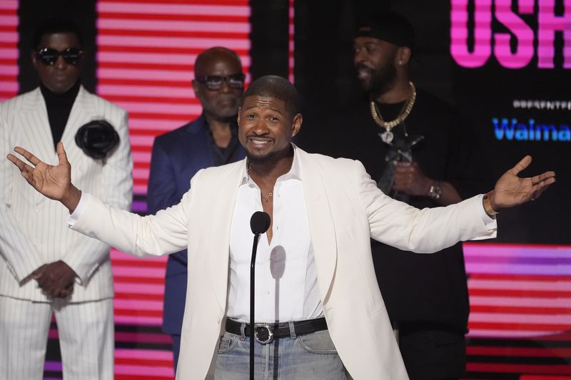 Usher accepts the Lifetime Achievement award during the BET Awards on Sunday, June 30, 2024, at the Peacock Theater in Los Angeles. Babyface, rear left, and L.A. Reid, rear center, look on.(AP Photo/Chris Pizzello)