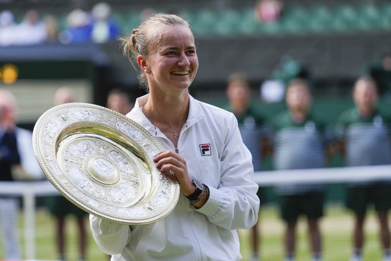 Barbora Krejcikova of the Czech Republic holds her trophy after defeating Jasmine Paolini of Italy in the women's singles final at the Wimbledon tennis championships in London, Saturday, July 13, 2024. (AP Photo/Kirsty Wigglesworth)