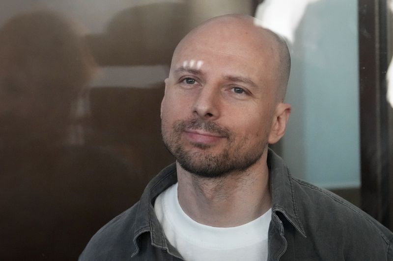 Russian journalist Sergey Karelin accused of working for a group founded by the late Russian opposition politician Alexei Navalny, stands in a defendant's cage of the Nagatinsky District Court in Moscow, Russia, on Wednesday, Oct. 2, 2024. (AP Photo)