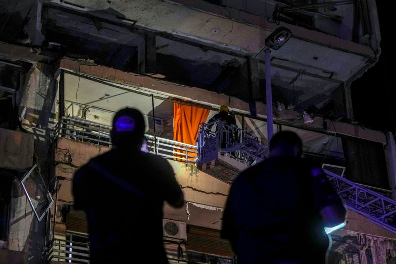 A fire engine ladder extends up a building that was hit in an apparent Israeli airstrike, in central Beirut, Lebanon, early Monday, Sept. 30, 2024. (AP Photo/Bilal Hussein)