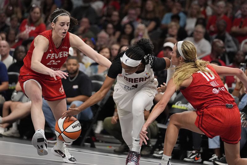 Indiana Fever's Caitlin Clark (22) and Atlanta Dream's Jordin Canada (3) both dive for the ball in the second half of an WNBA basketball game, Monday, Aug. 26, 2024, in Atlanta. (AP Photo/Brynn Anderson)