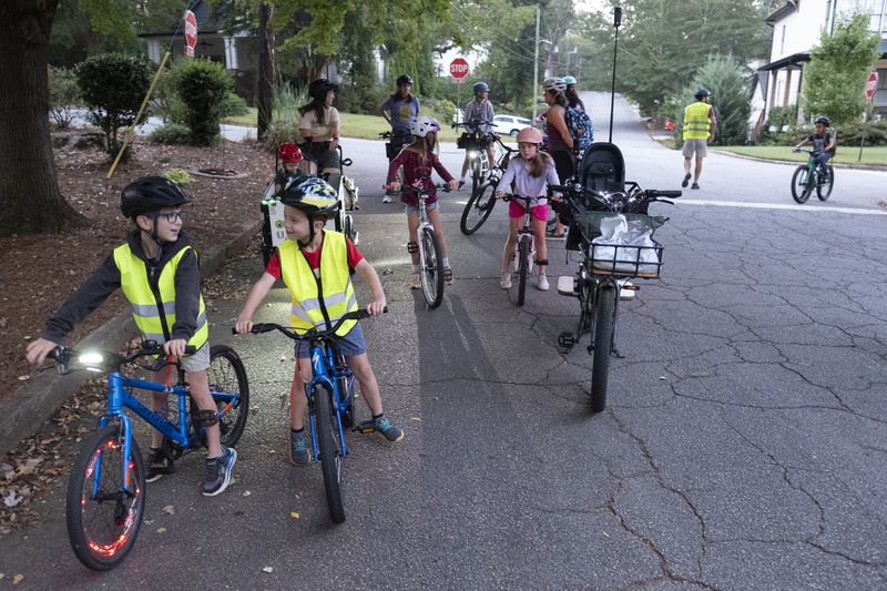 Participants in the weekly Parkside Elementary School “bike bus” pauses to regroup as they head towards the school Friday, Sept. 20, 2024, in Atlanta. Ben Gray for the Atlanta Journal-Constitution