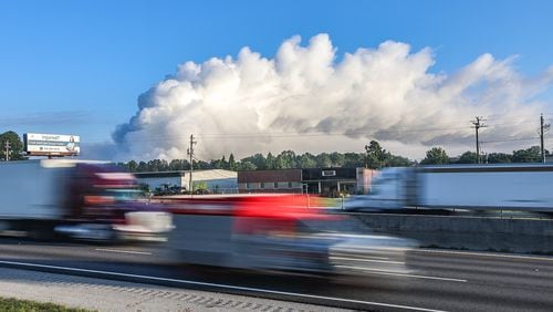 The large plume of smoke from a  chemical plant fire on Sunday is still visible from I-20 eastbound near West Avenue in Conyers on Monday morning. (John Spink / AJC)