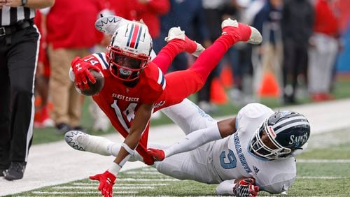 Sandy Creek wide receiver Dalen Penson (14) dives for extra yards as he is tackled by Cedar Grove linebacker Adonijah Green (9) during the first half in the GHSA Class 3A finals, at Center Parc Stadium, Saturday, December 10, 2022, in Atlanta. (Jason Getz / Jason.Getz@ajc.com)
