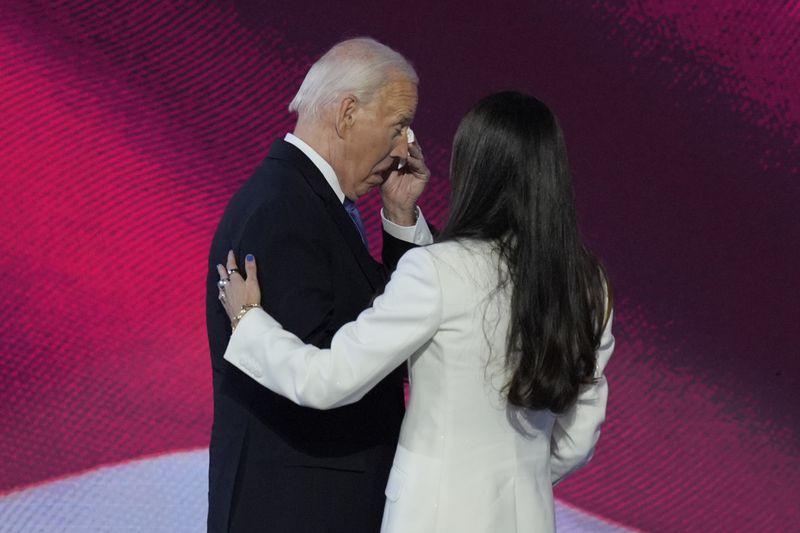 President Joe Biden, left, wipes his eyes after embracing his daughter Ashley Biden, right, on stage at the Democratic National Convention on Monday, Aug. 19, 2024, in Chicago. (AP Photo/J. Scott Applewhite)