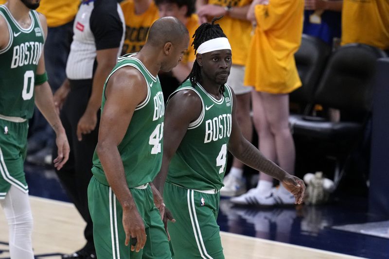 Boston Celtics guard Jrue Holiday (4) walks off the court with teammate Al Horford (42) after Game 3 of the NBA Eastern Conference basketball finals against the Indiana Pacers, Saturday, May 25, 2024, in Indianapolis. The Celtics won 114-111.(AP Photo/Darron Cummings)