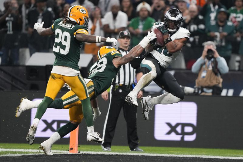 Philadelphia Eagles running back Saquon Barkley (26) scores past Green Bay Packers linebacker Isaiah McDuffie (58) during the first half of an NFL football game, Friday, Sept. 6, 2024, at the Neo Quimica Arena in Sao Paulo. (AP Photo/Doug Benc)