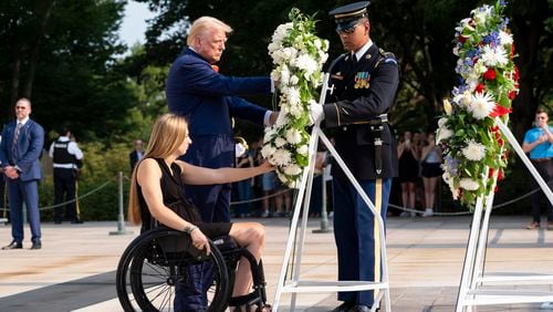 Former U.S. Marine Corps Cpl. Kelsee Lainhart left, and Republican presidential nominee former President Donald Trump place a wreath at the Tomb of the Unknown Solider in honor of the 13 service members killed at Abbey Gate, at Arlington National Cemetery, Monday, Aug. 26, 2024, in Arlington, Va. (AP Photo/Alex Brandon)