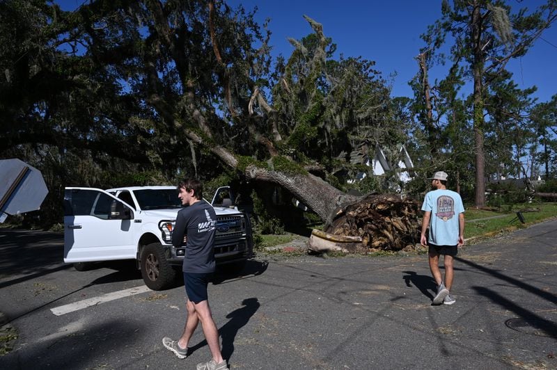 Austin Fosdick (left) and Nealy Hiers, both students at Valdosta State University, check out damages caused by Hurricane Helene near Valdosta State University, Saturday, September 28, 2024, in Valdosta. The devastation in Valdosta was extensive after the South Georgia city was battered with hurricane-force winds on Helene’s path across the state. Damaging Helene has swept through Georgia, leading to at least 15 deaths. All 159 counties are now assessing the devastation and working to rebuild, even as serious flooding risks linger. (Hyosub Shin / AJC)