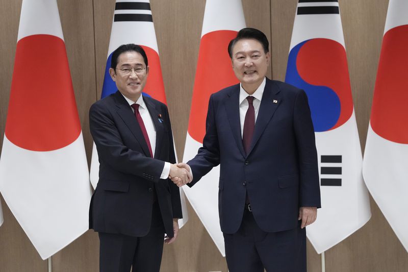 South Korean President Yoon Suk Yeol, right, shakes hands with Japanese Prime Minister Fumio Kishida during a meeting at the Presidential Office in Seoul, South Korea, Sunday, May 26, 2024. (AP Photo/Ahn Young-joon, Pool)
